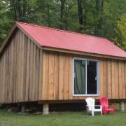 Custom built cottage with sliding glass door and red metal roof